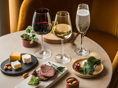 Três opções de vinho low carb com acompanhamentos compatíveis com dieta, sobre mesa elegante.